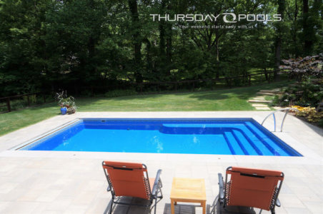 Thursday Pools side view of Ocean Lil Bob pool with two orange lounge chairs