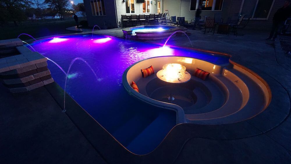 Thursday Pools side view of Cortona Spillover and sunken living room with LED lights and water features