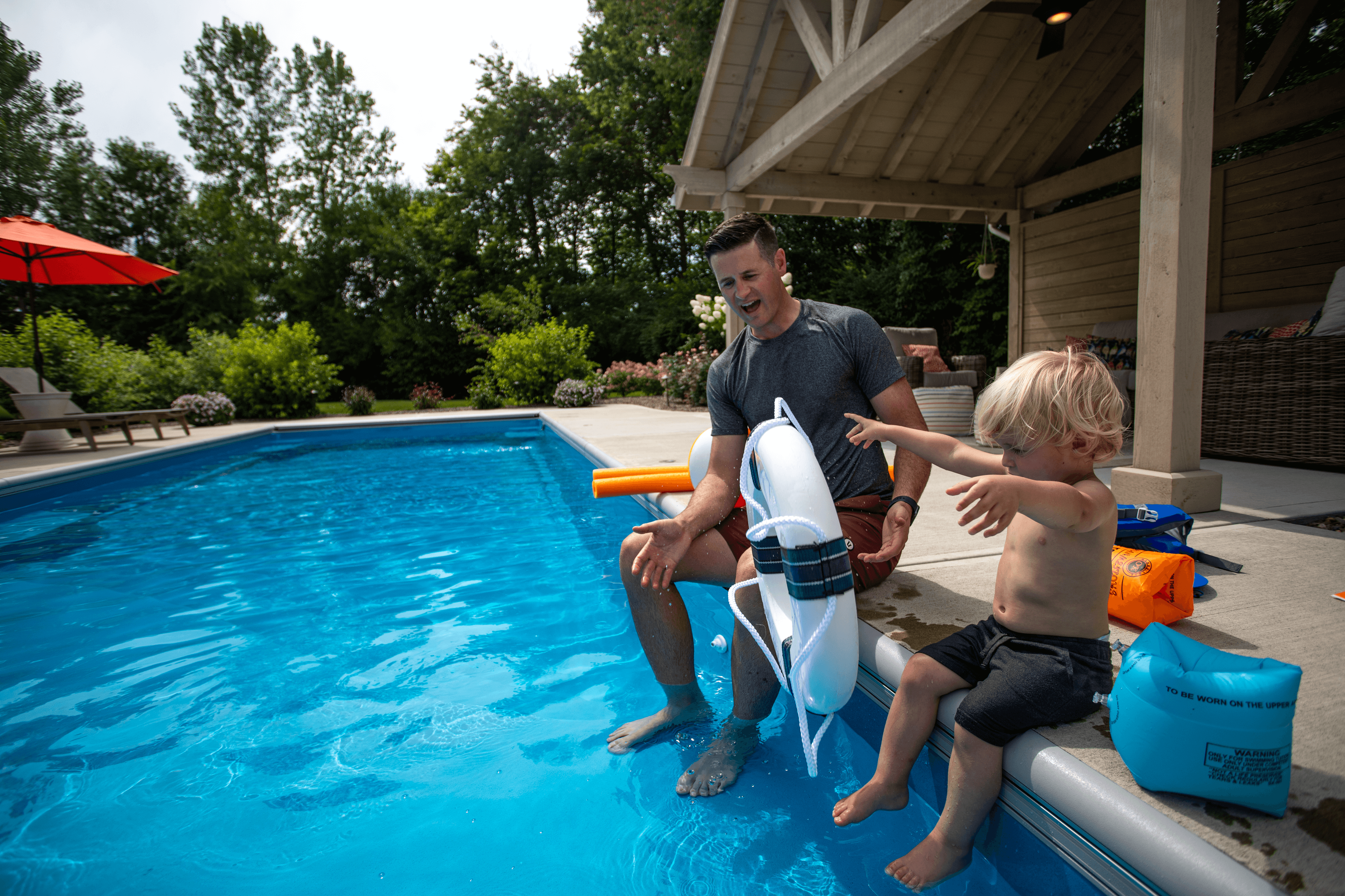 Thursday Pools kid playing in pool with dad watching
