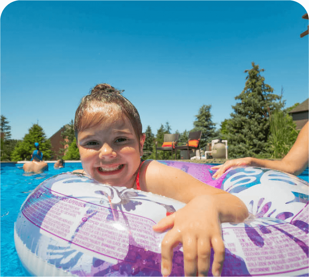 Thursday Pools girl laying on floatie in pool smiling at camera