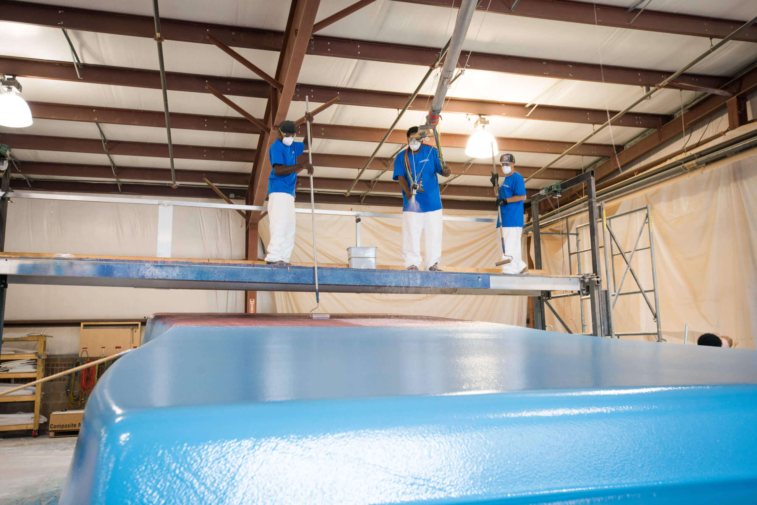 Thursday Pools three workers painting pool in warehouse