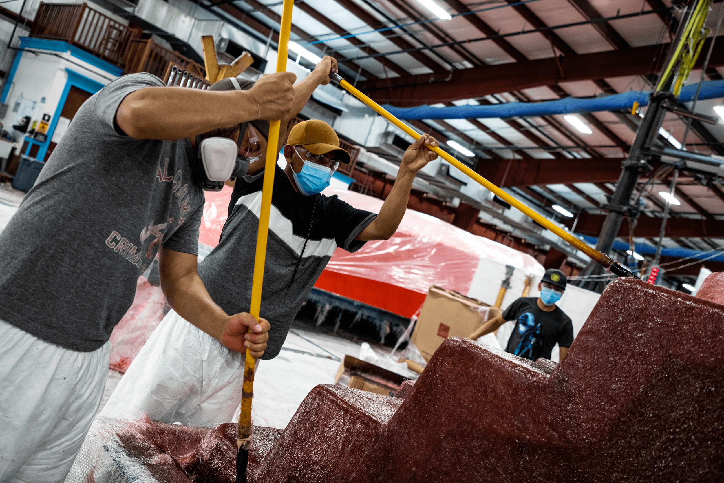 Thursday Pools' 2 men painting a pool in a fiberglass station during a manufacturing shoot.